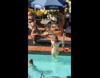 Woman in bikini poses on pool handrail