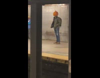 Guy wears pumpkin on head 