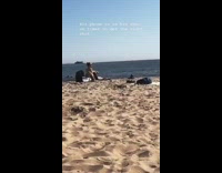 Guy takes picture on camera timer with phone in shoe at the beach
