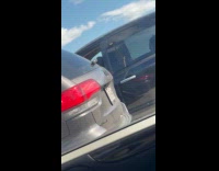 Man driving while cutting beard with scissors 