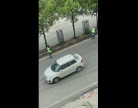 Green safety vest guy sweeps road street 