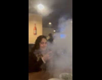 Woman shows food served with huge smoke