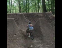 Woman rides up steep dirt hill on bike and falls back