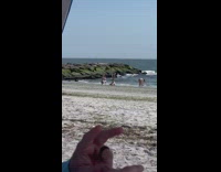 Girl in blue bikini sits on sand 