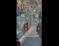 Woman orange dress building rooftop glass skyscraper