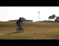 Guy bicycle grass hill yoga ball fail
