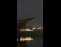 Silhouette man climb pier roof tip night