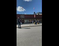 Two people dance street red building flag