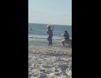 Man with a wig hair flip while girls splashes him