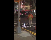 Man uses blow torch on the bicycle logo on the road