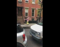 Woman pink jacket yellow skirt spin dance sidewalk