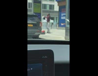 Red sweater guy sidewalk selfie phone charging 