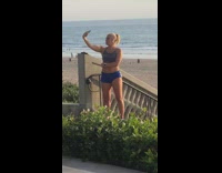 Girl blue shorts sports bra selfie beach