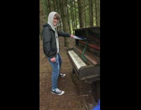 Guy plays on abandoned piano with umbrella