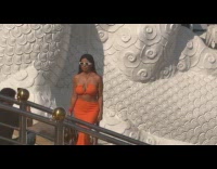 Woman orange dress poses near temple statues