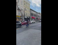 Guy bikes with car tire on head 
