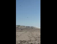 Group of people in white outfit dances at the beach