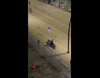 Lady in pink twerks for video against street barrier 