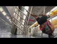 Person does a pole dance move on the subway train pole