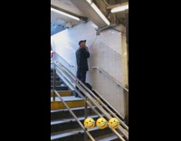 Guy on subway stairs  uses electric shaver