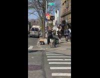 Guy on sidewalk blows into horn 