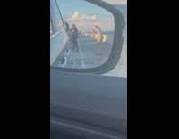 Woman in black top poses beside the car in traffic