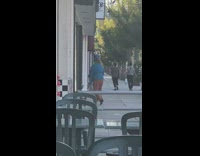 Woman blue sleeves brown pants street chairs