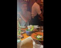 Man films food with light inside restaurant