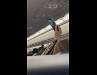 Woman leopard print jacket selfie airplane seat