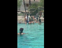 Man and woman impersonate Elvis at the poolside