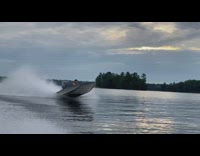 Man Drives and Steers Speedboat on Lake