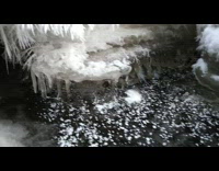 Spiky ice crystals inside water stream cave