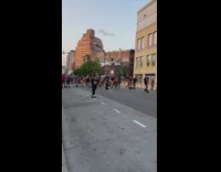 Crowd of rollerskaters going down street in group