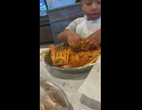 Kid happily drink and eats  seafood boil 