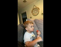 Little boy has mom hold partially eaten strawberries 