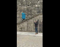 Man blue box costume climbs stairs park