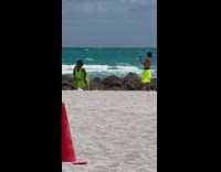 Woman in neon green beach dress twerks at the beach