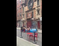 Women swims on pool while friends drink at table 