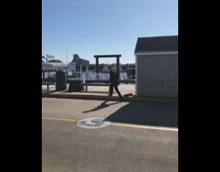Guy in business suit takes of shoes and front flip dives into ocean water