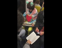 Guy dresses as fox on subway playing piano with strawberry necklace