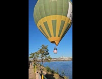 Man in air balloon waves at people below