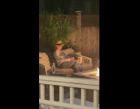 Old Woman sits by the fire films it with camera