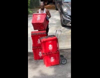 Man wears tank top carries biohazard box