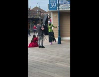Woman with colorful hair under pier 39 flag