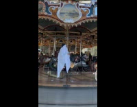 Collab WINY - Guy wears ghost costume sunglasses rides carousel 