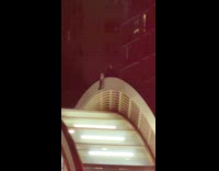 Person sitting on top of subway entrance roof 