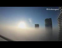 White clouds move by high rise buildings 