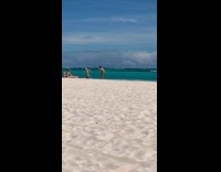 Woman bikini headstand for video at beach