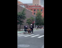 Man on motorcycle pulls desk on street