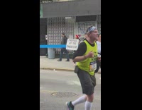Person holding sign that says poppers at the finish at NY Marathon